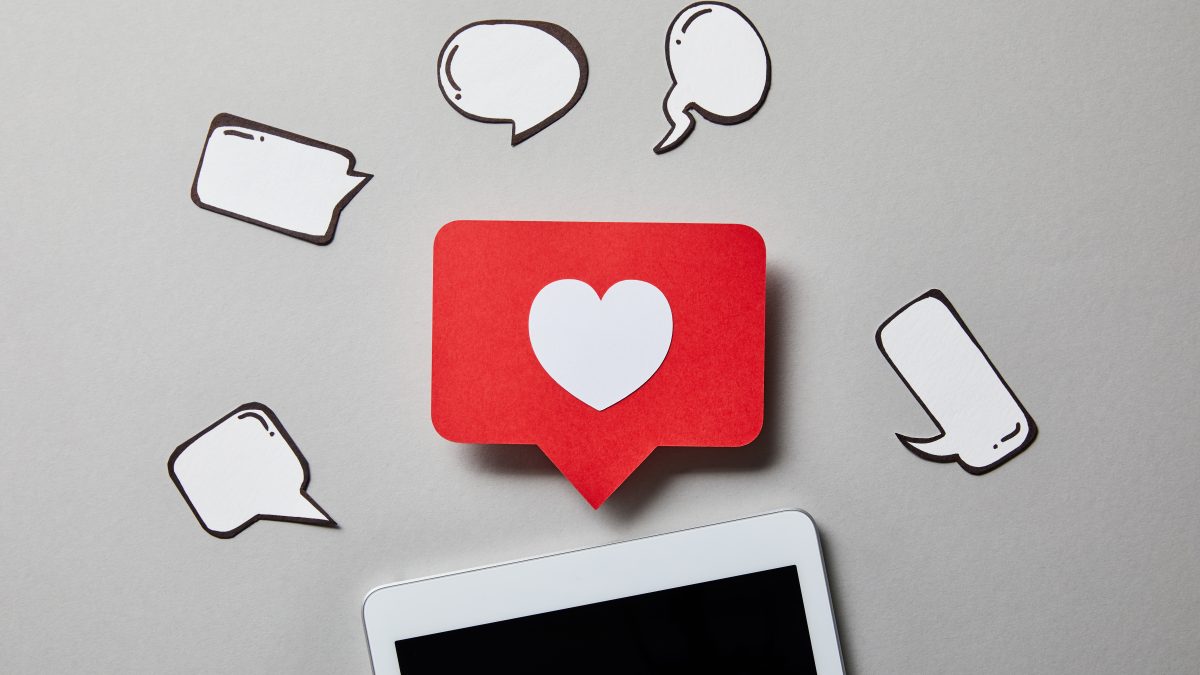 digital tablet with paper like sign, thought and speech bubbles on white surface