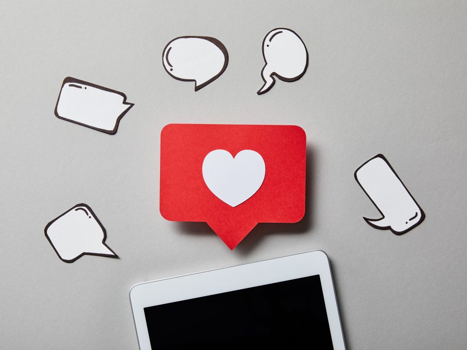 digital tablet with paper like sign, thought and speech bubbles on white surface