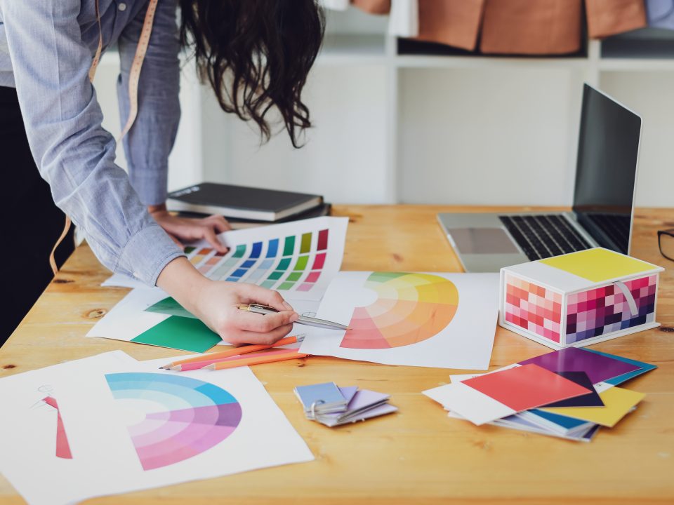 Young asian woman fashion designer working on her designs in the studio.